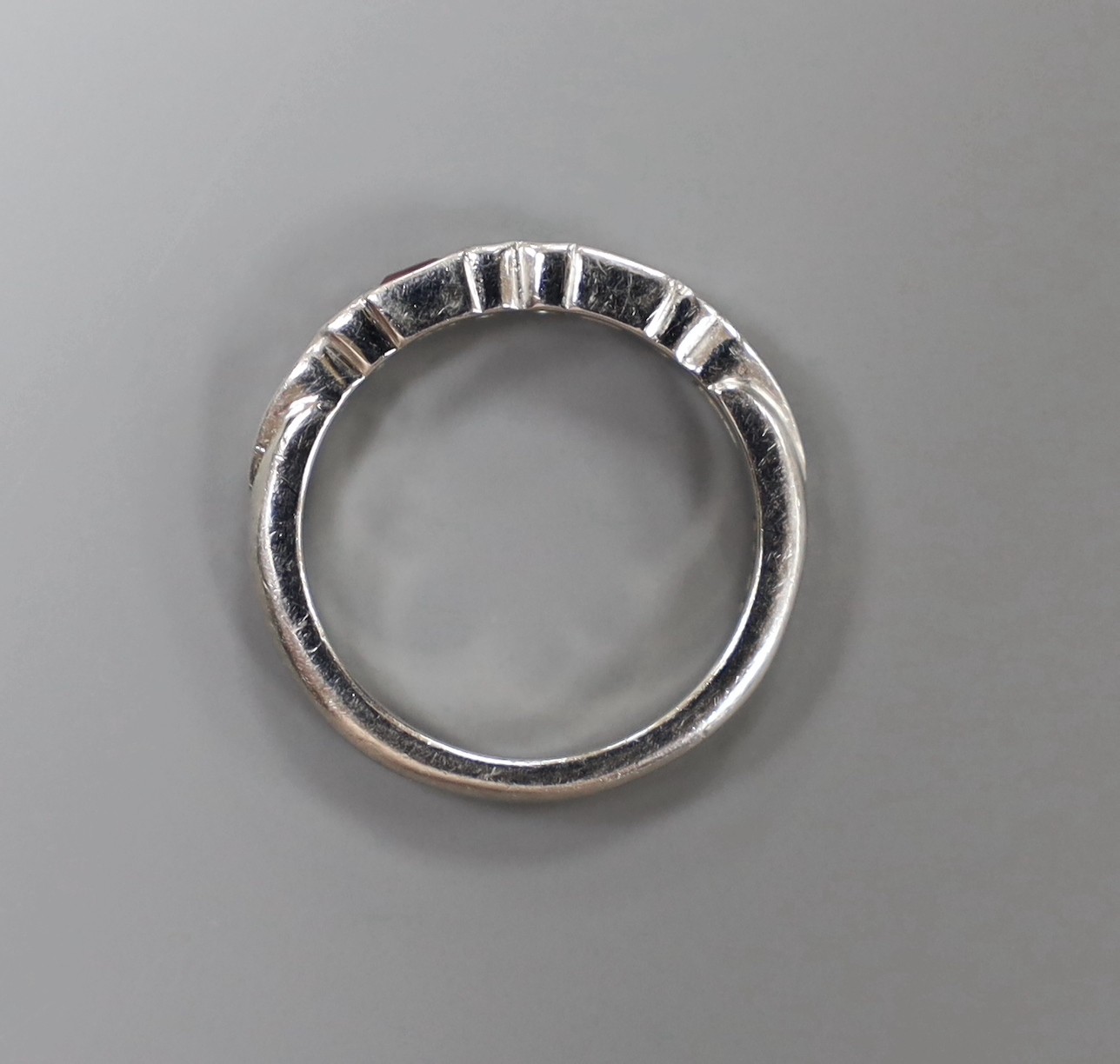 A modern platinum, two stone pink sapphire and six stone diamond set half hoop ring, size H, gross weight 3.9 grams.